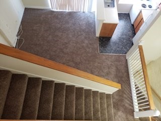 an overhead view of a carpeted staircase in a house